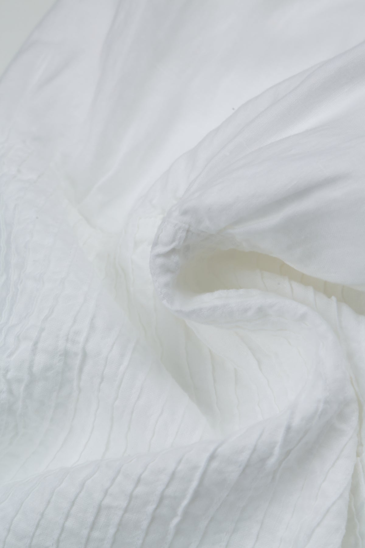 Ärmelloses weißes Leinenkleid mit Biesenfalten